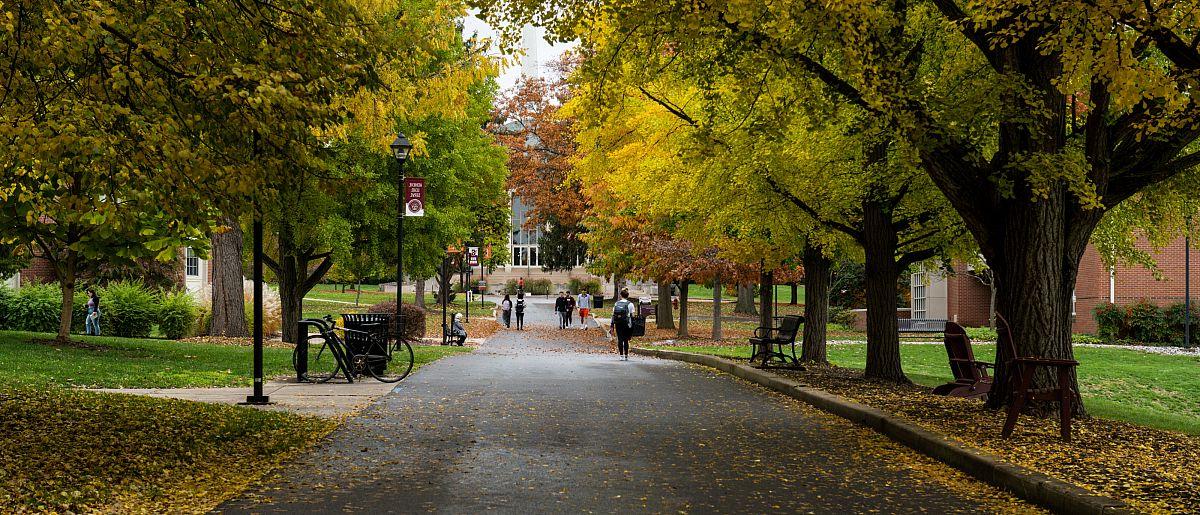 Image of Kurtz Lane in the fall with students walking in the distance. 