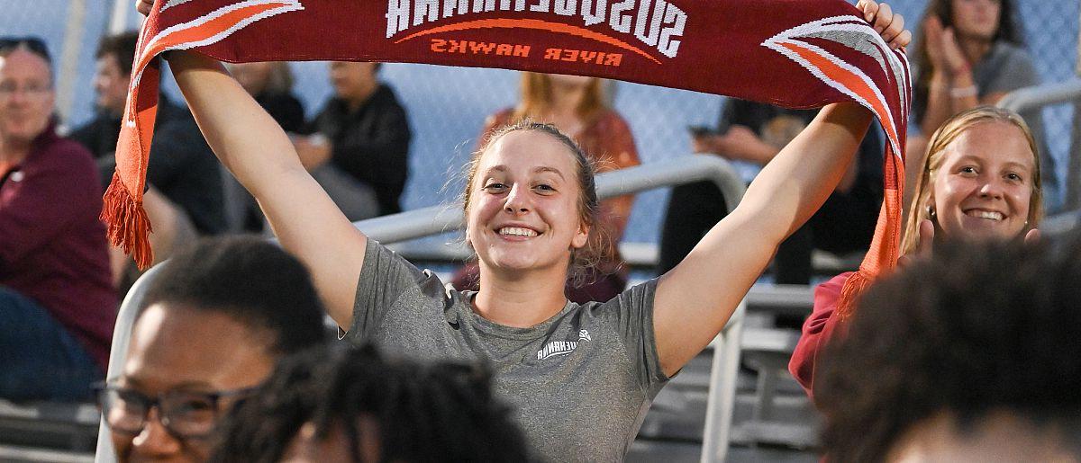 Fan holding up a Susquehanna banner in a crowded stadium.