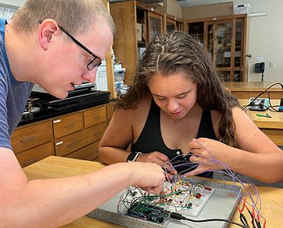 卡尔•福斯特, chair and associate professor of 物理, assists Hannah Needham '23 in the lab.